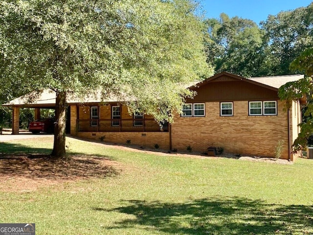 view of side of property featuring a carport and a yard