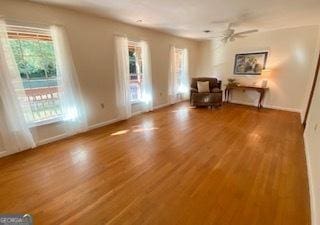 unfurnished room featuring hardwood / wood-style floors, a healthy amount of sunlight, and ceiling fan