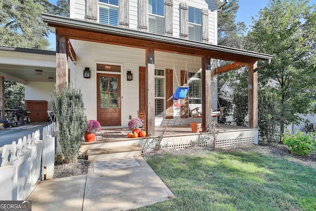 entrance to property featuring a yard and a porch