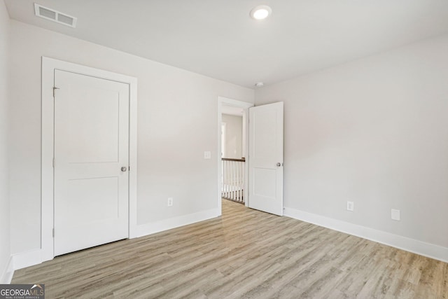 unfurnished bedroom with light hardwood / wood-style floors and a closet