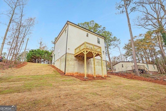 back of house featuring a yard and a wooden deck