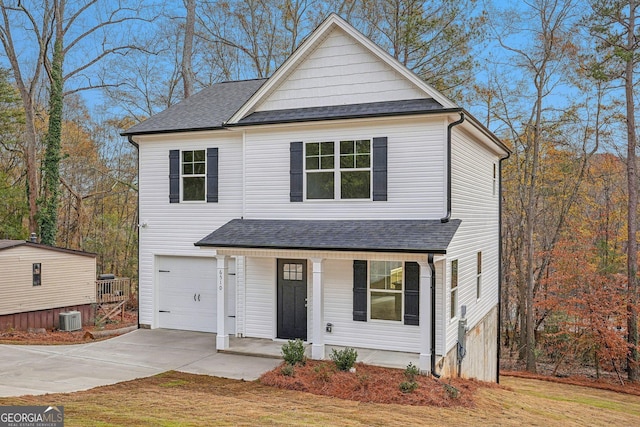 view of front of property with a front yard, a garage, and central AC unit