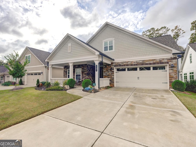 craftsman house with a garage, a front yard, and a porch