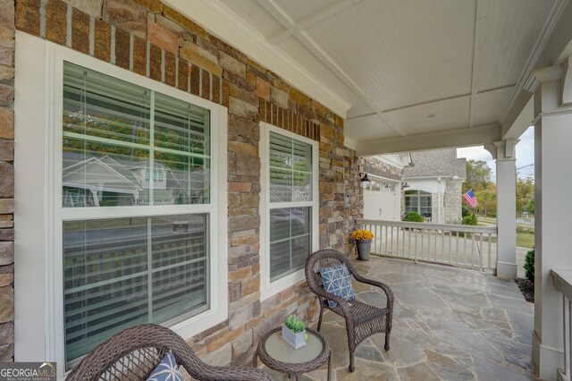 view of patio with a garage and a porch