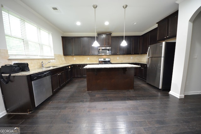 kitchen featuring a center island, stainless steel appliances, dark wood-type flooring, dark brown cabinets, and decorative light fixtures