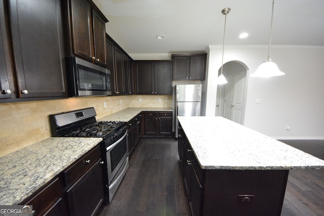 kitchen featuring decorative backsplash, a kitchen island, dark hardwood / wood-style flooring, light stone counters, and stainless steel appliances