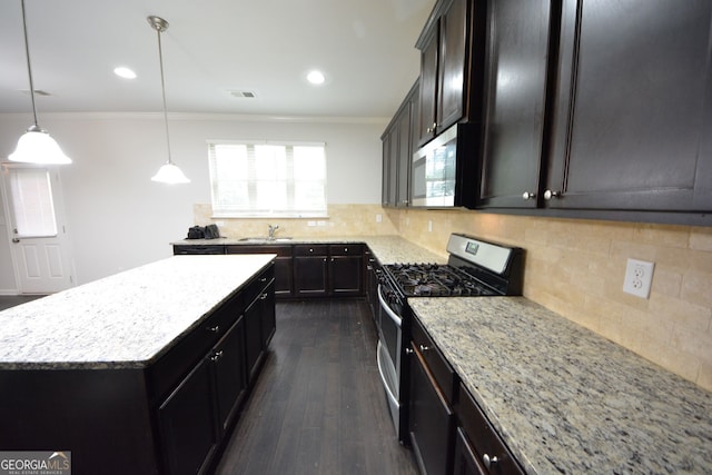 kitchen with a kitchen island, light stone countertops, dark hardwood / wood-style flooring, pendant lighting, and appliances with stainless steel finishes