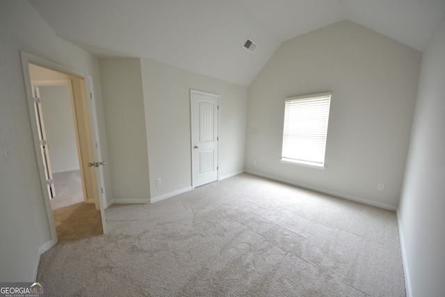 unfurnished bedroom with lofted ceiling and light carpet