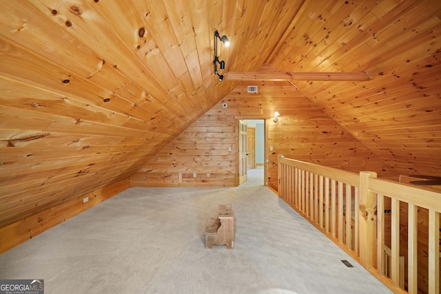 additional living space with vaulted ceiling, wood walls, wooden ceiling, and carpet