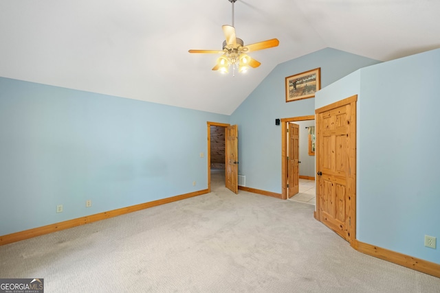 unfurnished bedroom with ceiling fan, light colored carpet, and lofted ceiling