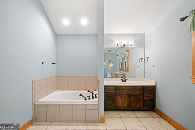 bathroom with lofted ceiling, tile patterned floors, tiled tub, and vanity