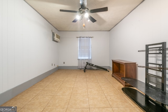 tiled spare room featuring ceiling fan, a wall mounted AC, a textured ceiling, and wood walls