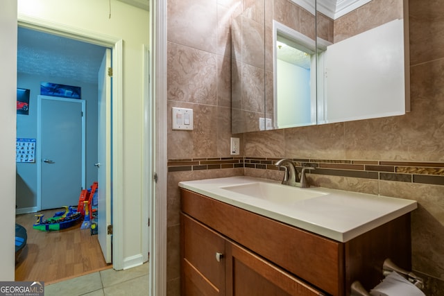 bathroom with hardwood / wood-style flooring, vanity, and tile walls