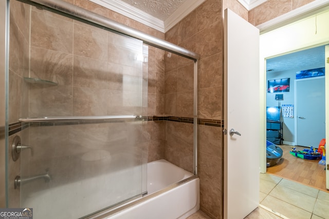 bathroom with ornamental molding, hardwood / wood-style floors, a textured ceiling, and combined bath / shower with glass door