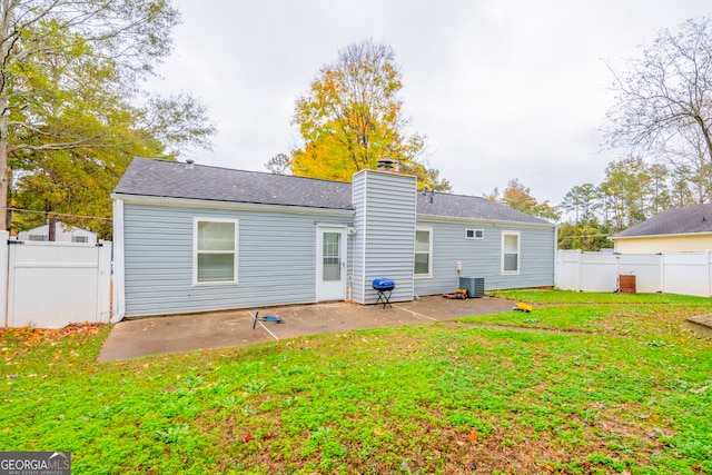 back of house featuring cooling unit, a yard, and a patio area