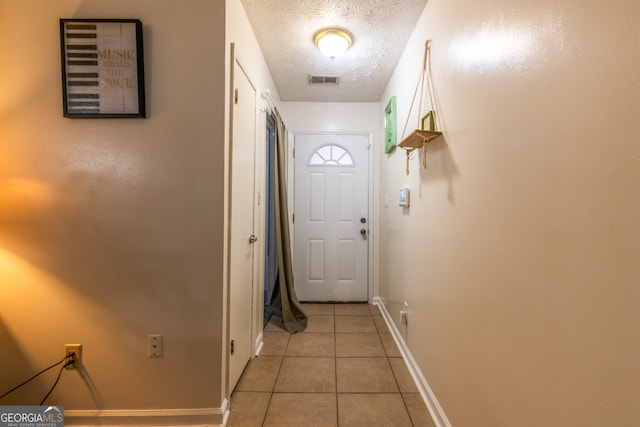 entryway featuring a textured ceiling and light tile patterned floors