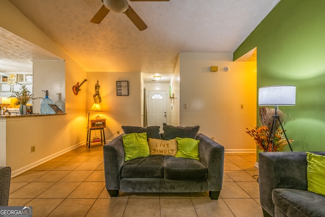 tiled living room with ceiling fan and a textured ceiling