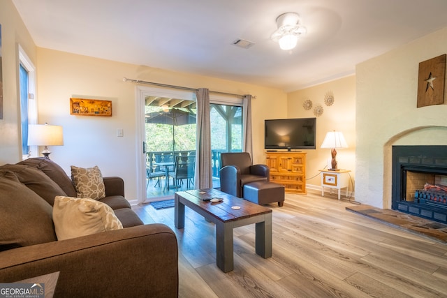 living room with light wood-type flooring and ceiling fan