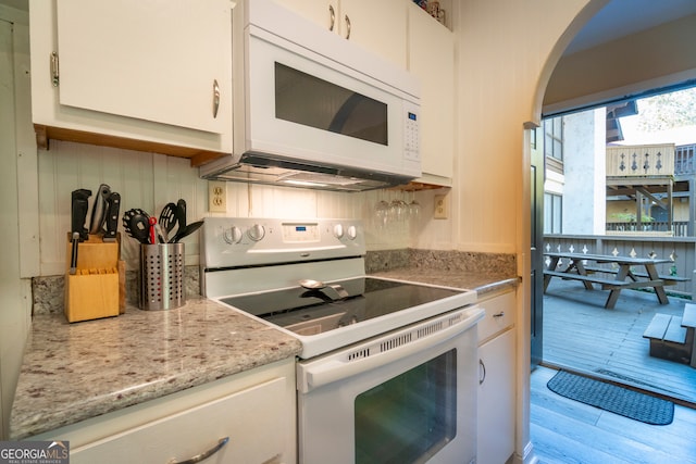 kitchen with light hardwood / wood-style floors, white appliances, and white cabinetry