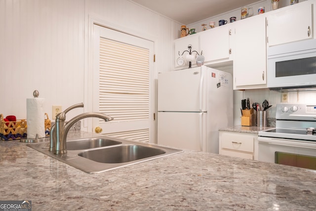 kitchen with light stone counters, white appliances, sink, and white cabinets