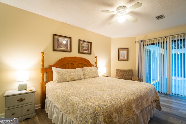 bedroom featuring ceiling fan, dark wood-type flooring, and a textured ceiling