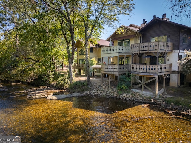 back of house featuring a deck with water view