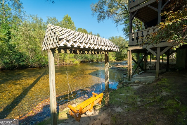 view of dock with a water view, a gazebo, and a lawn