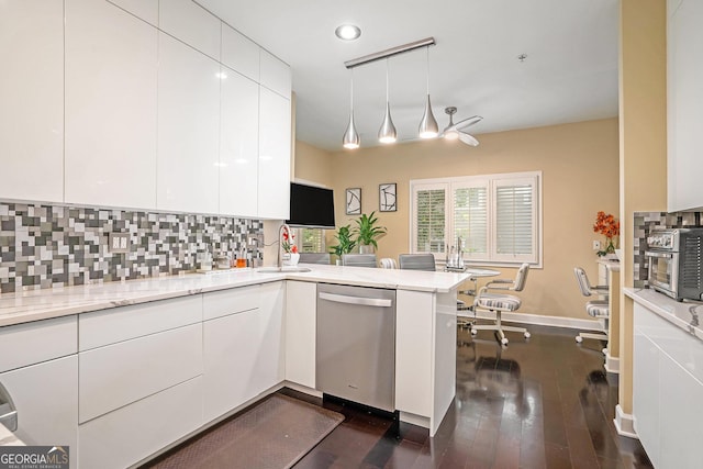 kitchen with decorative light fixtures, white cabinetry, decorative backsplash, stainless steel dishwasher, and kitchen peninsula