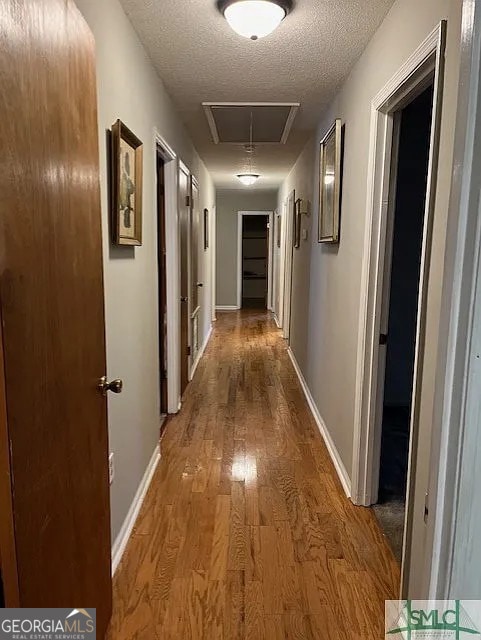 hallway featuring hardwood / wood-style floors and a textured ceiling