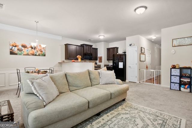 living room with light carpet, crown molding, and a chandelier