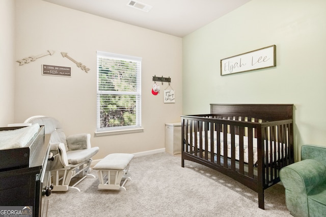 bedroom with a nursery area and light colored carpet