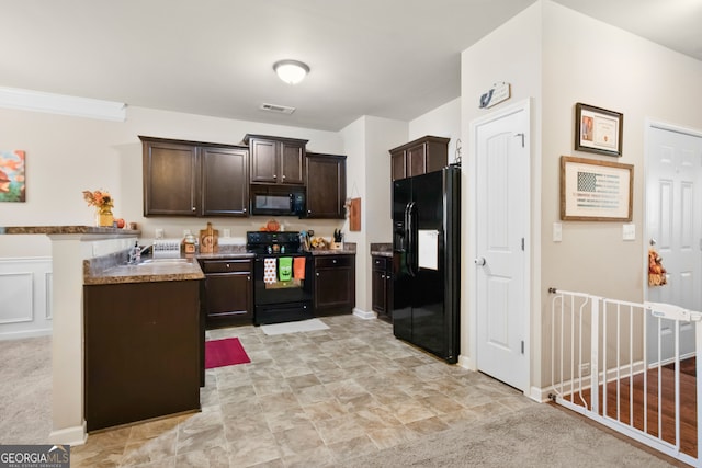 kitchen featuring dark brown cabinetry, light colored carpet, and black appliances