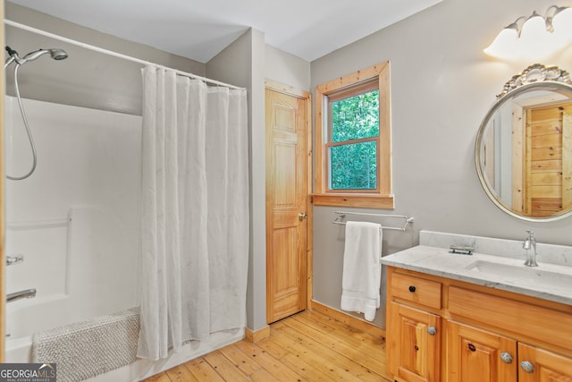 bathroom with shower / tub combo with curtain, wood-type flooring, and vanity