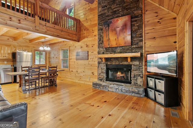 living room featuring wood walls, wooden ceiling, light wood-type flooring, and a stone fireplace