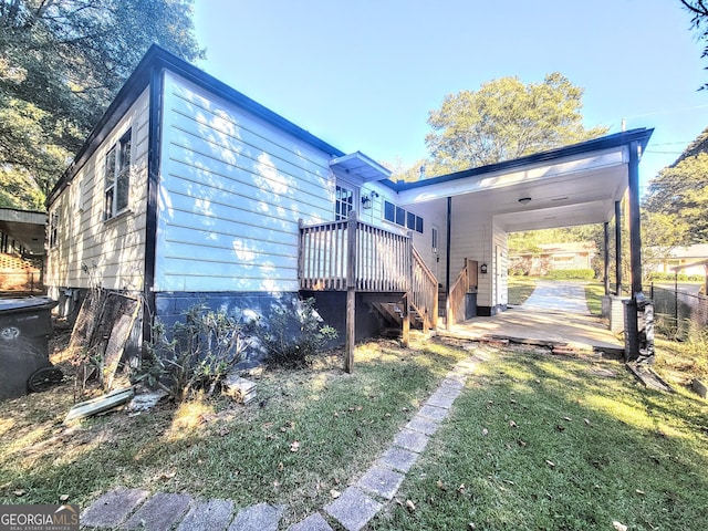 exterior space featuring a carport, a lawn, and a wooden deck