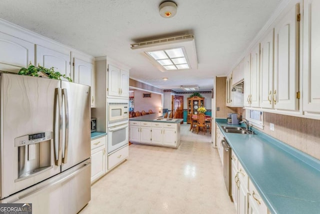 kitchen with white cabinetry, sink, ornamental molding, appliances with stainless steel finishes, and a textured ceiling