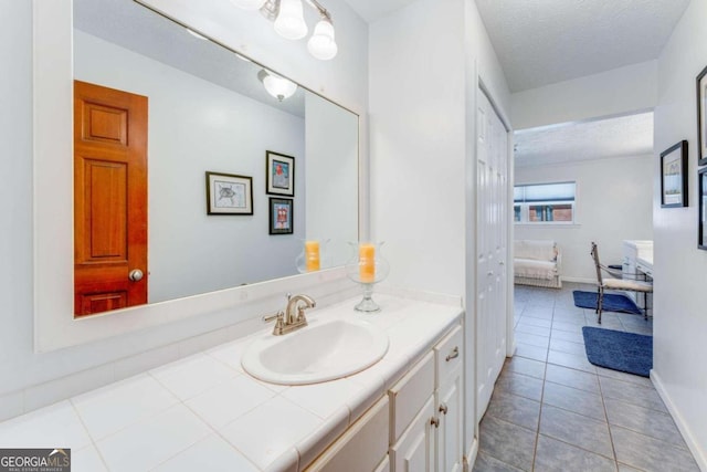 bathroom featuring tile patterned flooring, vanity, and a textured ceiling