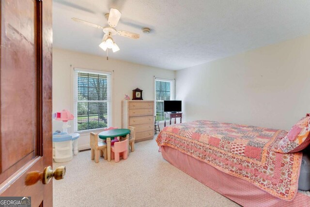 bedroom with carpet floors, a textured ceiling, and ceiling fan