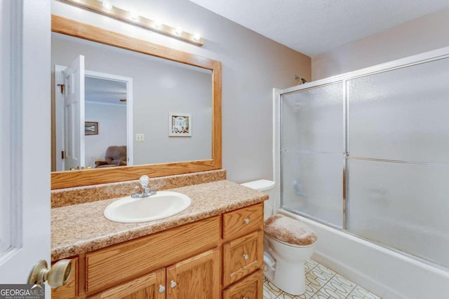 full bathroom with toilet, bath / shower combo with glass door, vanity, and a textured ceiling