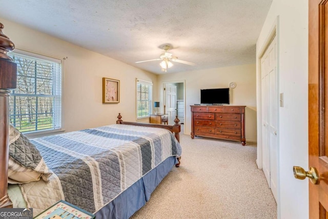 carpeted bedroom with ceiling fan, a textured ceiling, and a closet