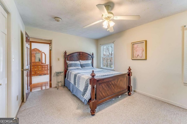 carpeted bedroom with ceiling fan and a textured ceiling