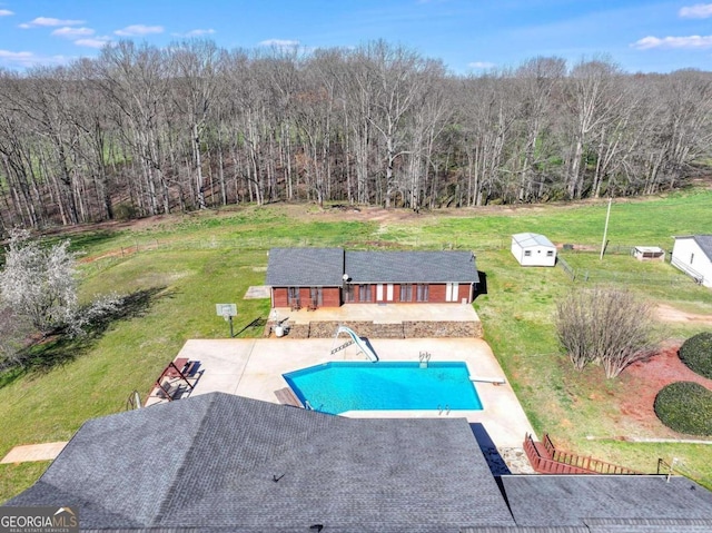 view of pool with a yard, a water slide, a patio, and a diving board