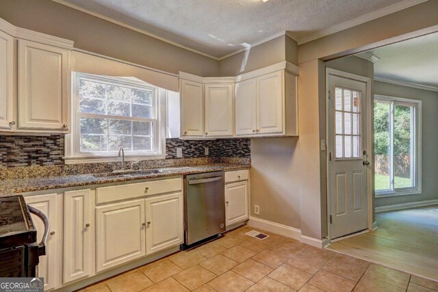 kitchen featuring stove, dark stone counters, sink, dishwasher, and light tile patterned flooring