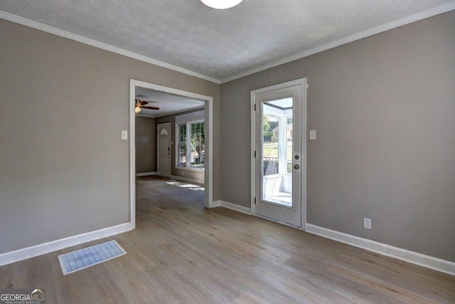 unfurnished room with ceiling fan, ornamental molding, a textured ceiling, and light hardwood / wood-style flooring