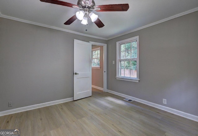 empty room featuring light hardwood / wood-style floors, ceiling fan, and crown molding