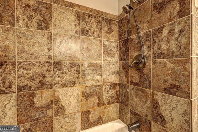 interior details featuring tiled shower / bath combo