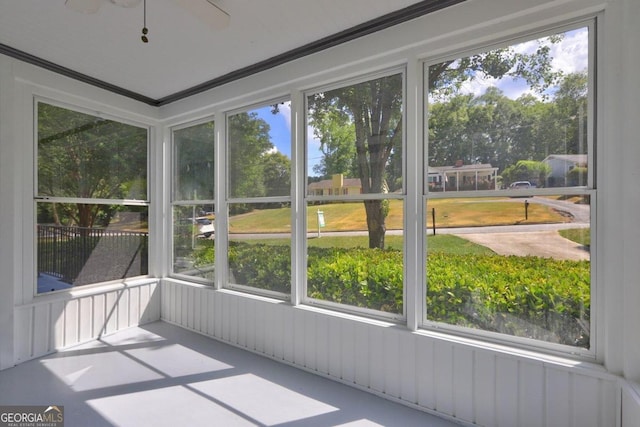 unfurnished sunroom with ceiling fan