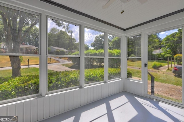 unfurnished sunroom featuring ceiling fan and a healthy amount of sunlight