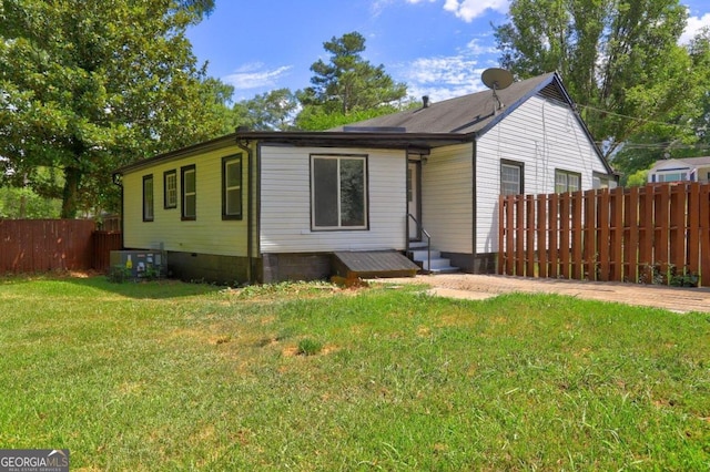 view of front of home featuring a front yard and central air condition unit