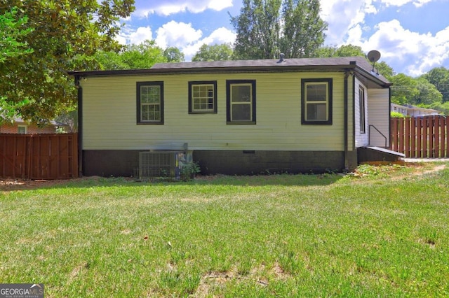 back of house featuring cooling unit and a yard